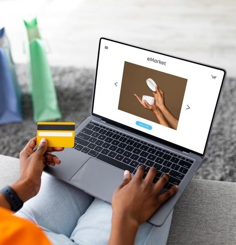 millennial-black-woman-using-laptop-with-cream-screen-credit-card